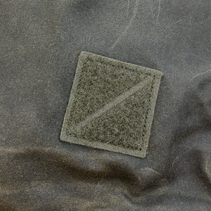 Textured green patch on a olive fabric background