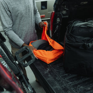 Transit Packing Cube 10L in Hot Orange - opening and packed with clothes