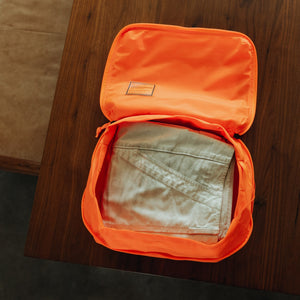 Transit Packing Cube 10L in Hot Orange - packed with pants