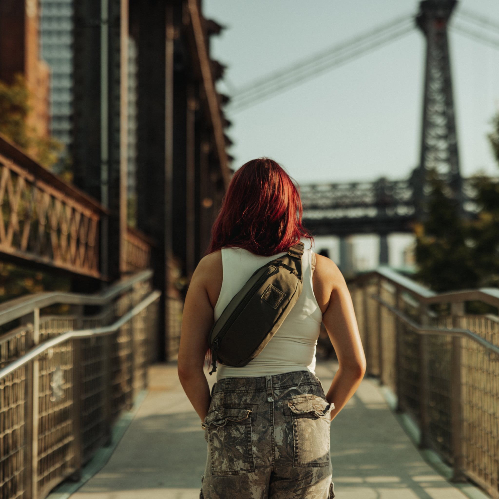 CIVIC Access Sling 2L - CAS2 in OD Green - worn in sling mode walking towards Brooklyn Bridge [13011c-ODG]