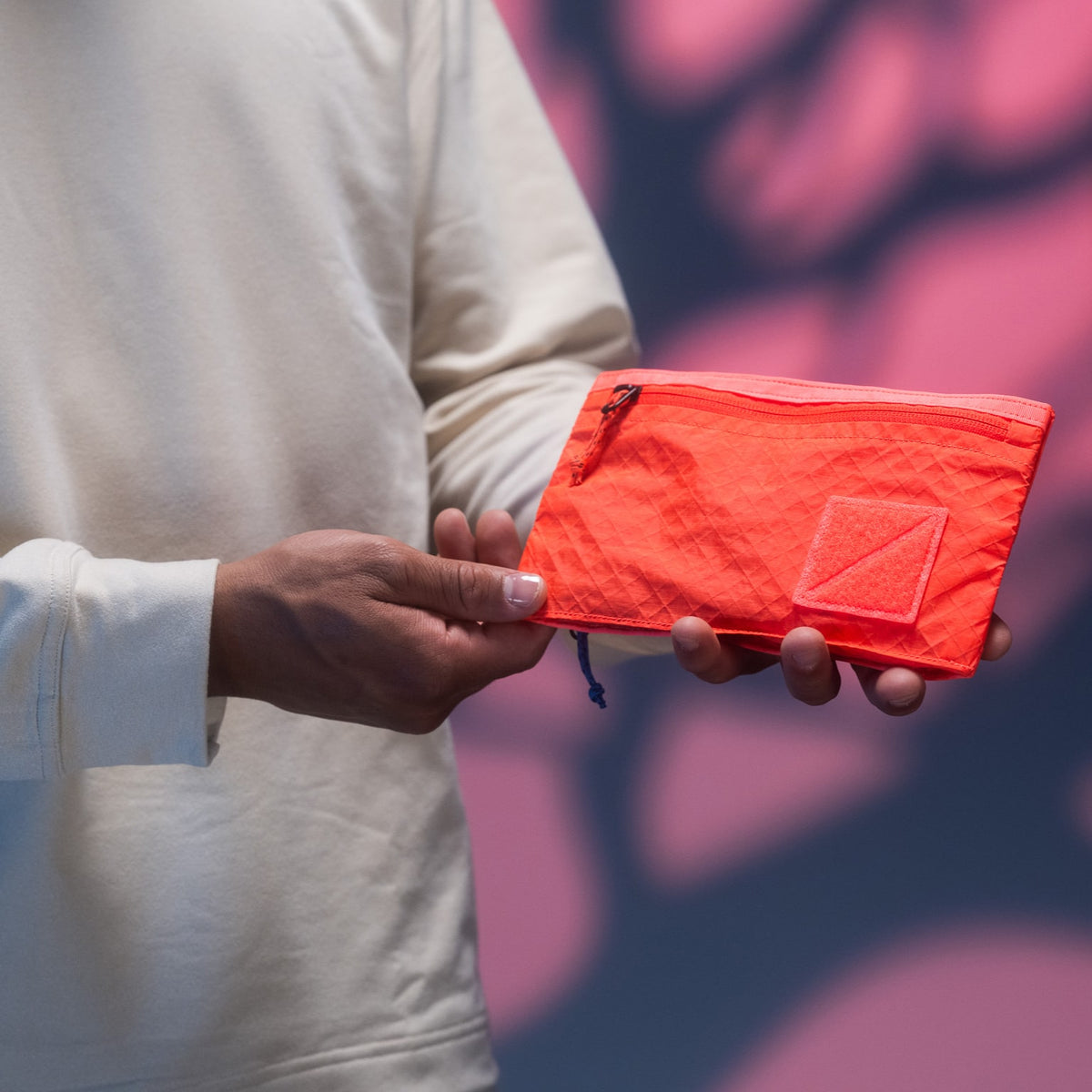 CIVIC Flat Pouch - CFP - in Electric Coral -  held by model in hands