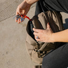 Person holding a CIVIC Half Zip 22L in Fossil Brown and key leash on a concrete surface Person holding a CIVIC Half Zip 22L in Fossil Brown and key leash on a concrete surface [13003d-FBN
