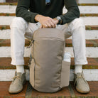 Person sitting on steps with a CIVIC Half Zip 22L in Fossil Brown backpack Person sitting on steps with a CIVIC Half Zip 22L in Fossil Brown backpack [13003d-FBN