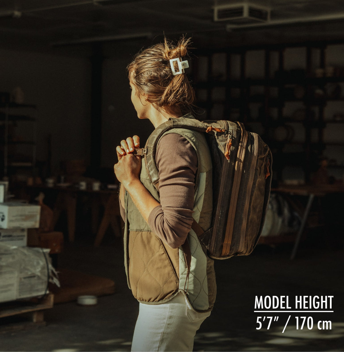 Person wearing CIVIC Panel Loader 16L, side view in a garage.