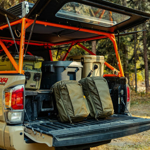 CIVIC Travel Bag 26L in OD Green next to CIVIC Travel Bag 20L in OD Green on truck bed