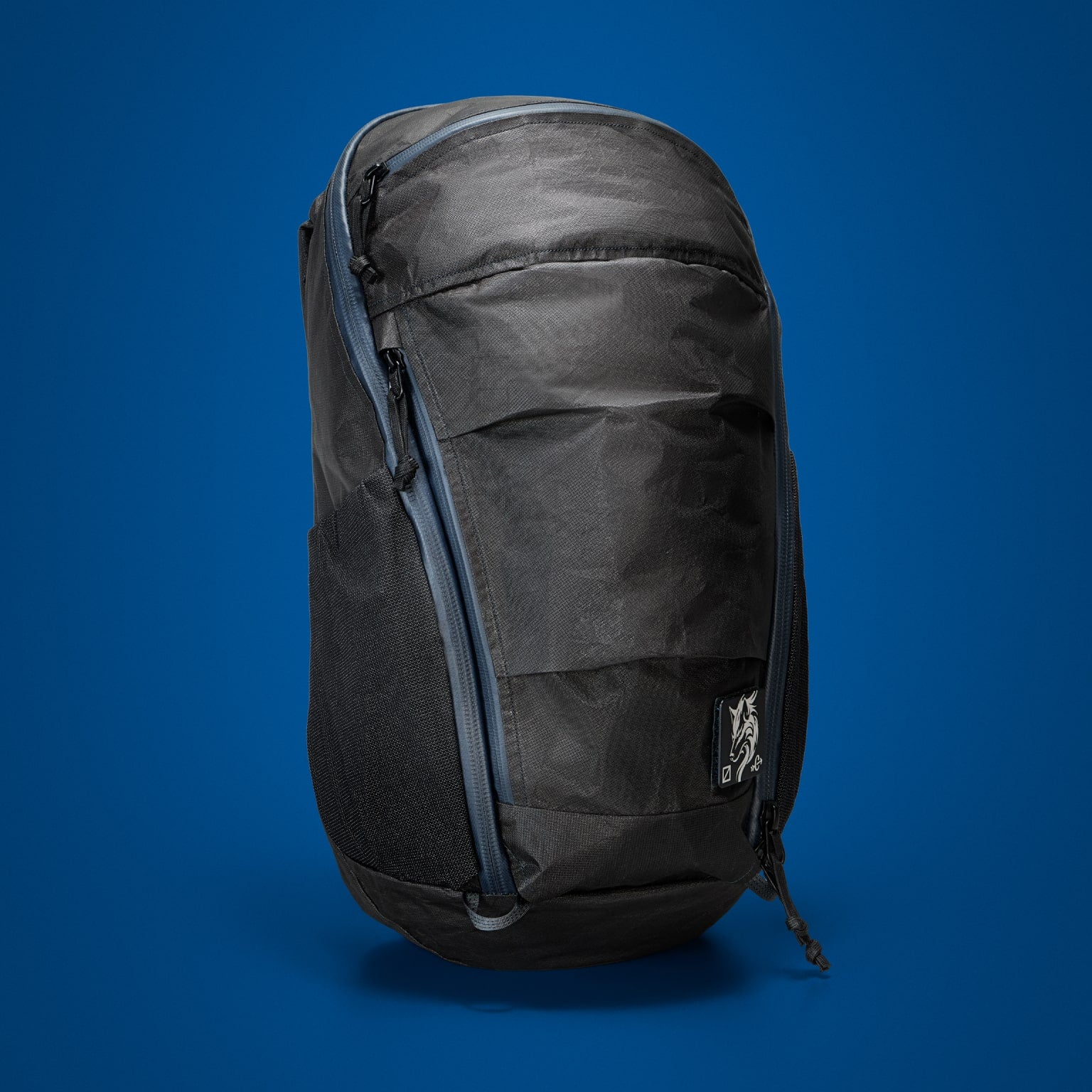 MOUNTAIN Panel Loader 22L in Black Magic. Front of pack on blue background
