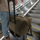 ransit Duffel 25L in OD Green on roller luggage in airport escalator ransit Duffel 25L in OD Green on roller luggage in airport escalator [13023d-ODG