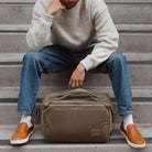 Person sitting on steps with a Transit Duffel 25L in OD Green in front of them Person sitting on steps with a Transit Duffel 25L in OD Green in front of them [13023d-ODG