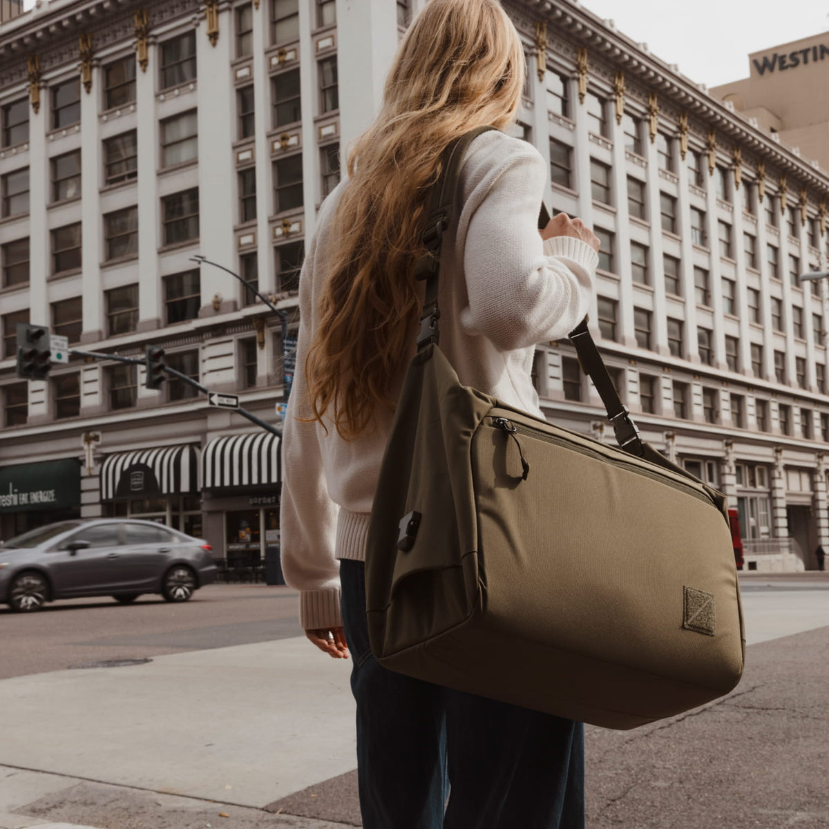 Transit Duffel 35L in OD Green carried in city by shoulder strap