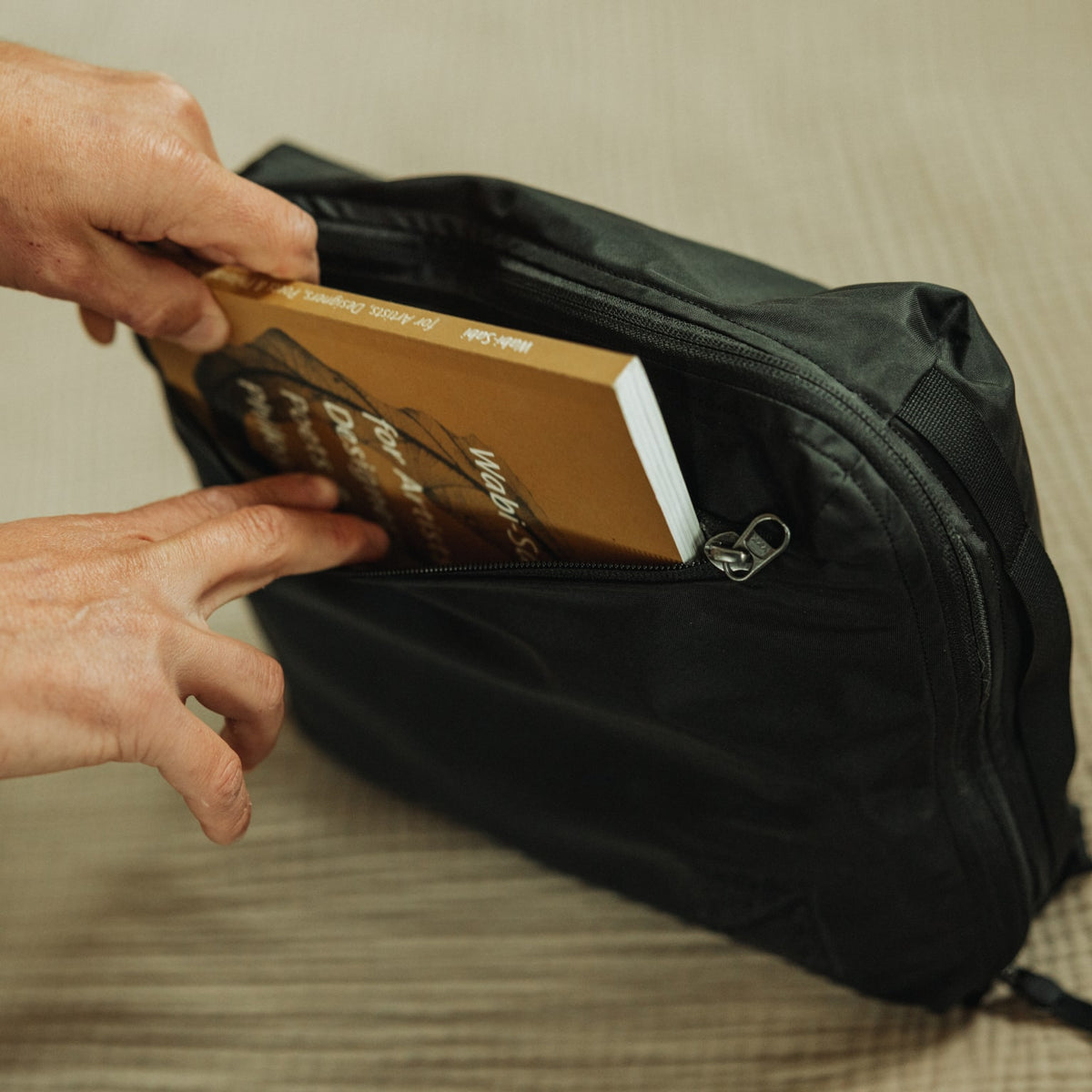 Transit Packing Cube 10L in Black - quick access pocket with book