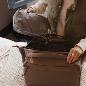 Transit Packing Cube 4L in Standard Gray - being packed into fossil brown transit duffel