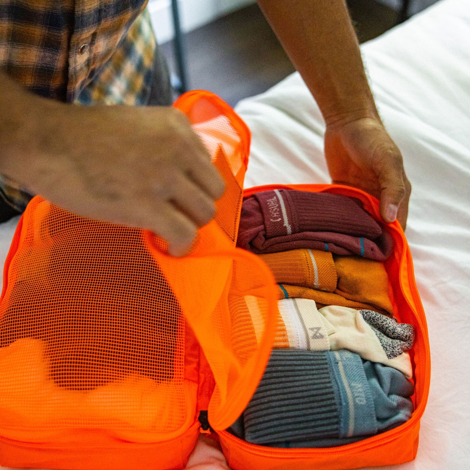 Transit Packing Cube 8L in Hot Orange open on bed [13015a-HTO]