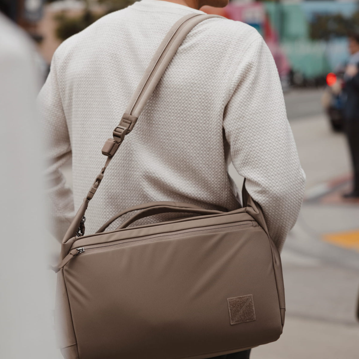 Person wearing a Transit duffel with Transit Strap on a city street