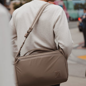 Person wearing a Transit duffel with Transit Strap on a city street
